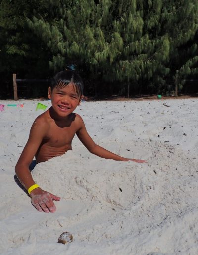 Kid covered in sand at whitehaven beach