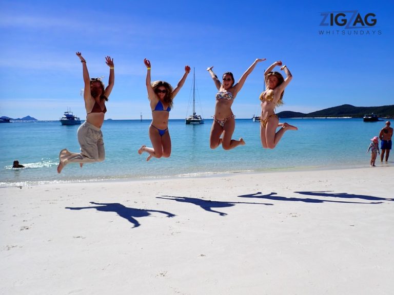 4 friends jumping high at the beach